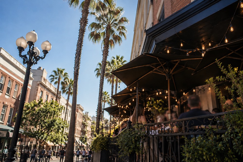 Busy restaurant terrace with string lights on a Gaslamp street corner