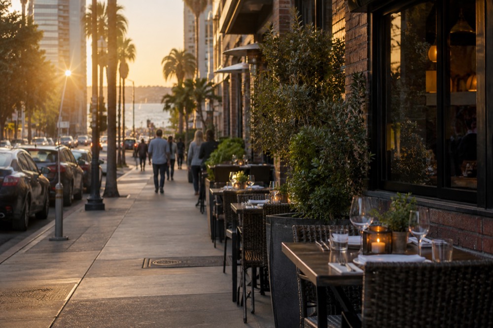Tables set for dinner on a sidewalk outside a brick restaurant front