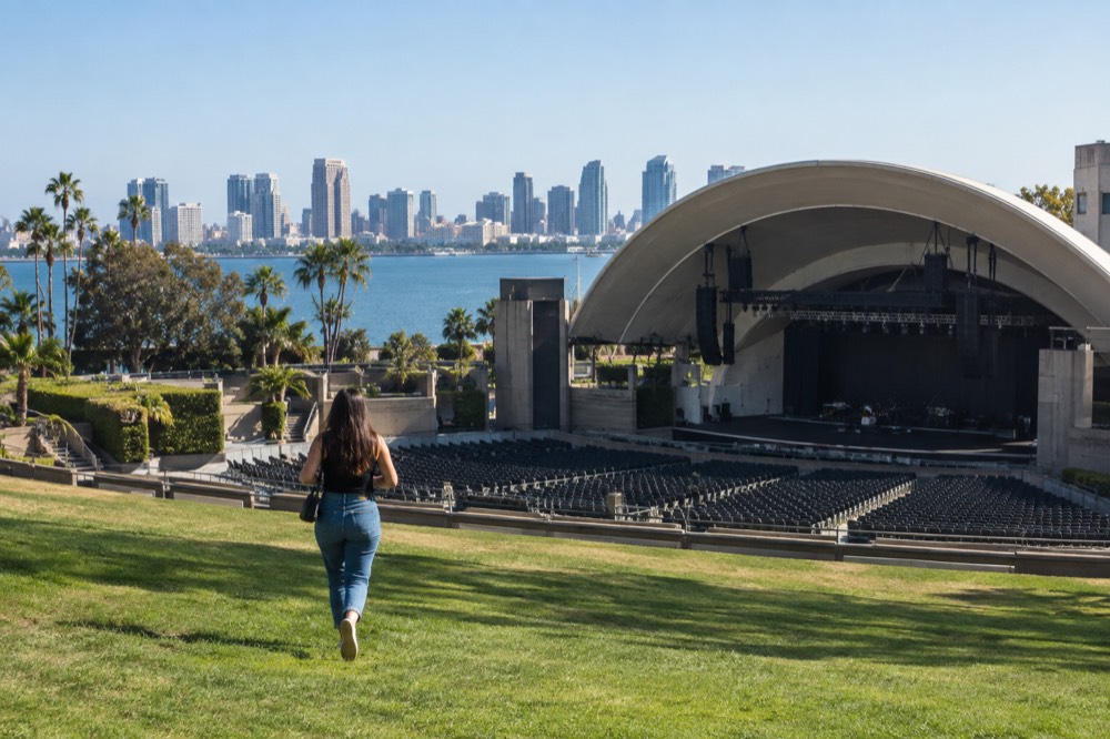 A large outdoor amphitheater seen from the back lawn with rows of empty seats before a show