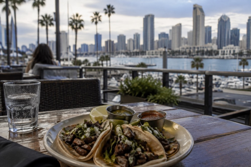 A plate of carne asada tacos with salsa and lime on a restaurant table