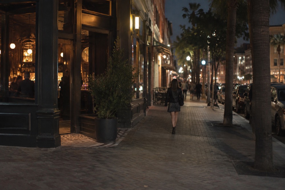 A Gaslamp Quarter street at night with lit storefronts and a corner bar entrance