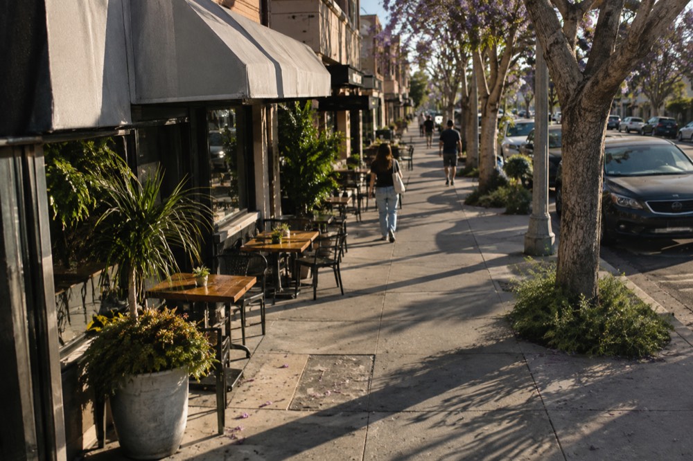 A sunny San Diego street lined with small storefronts and outdoor patios