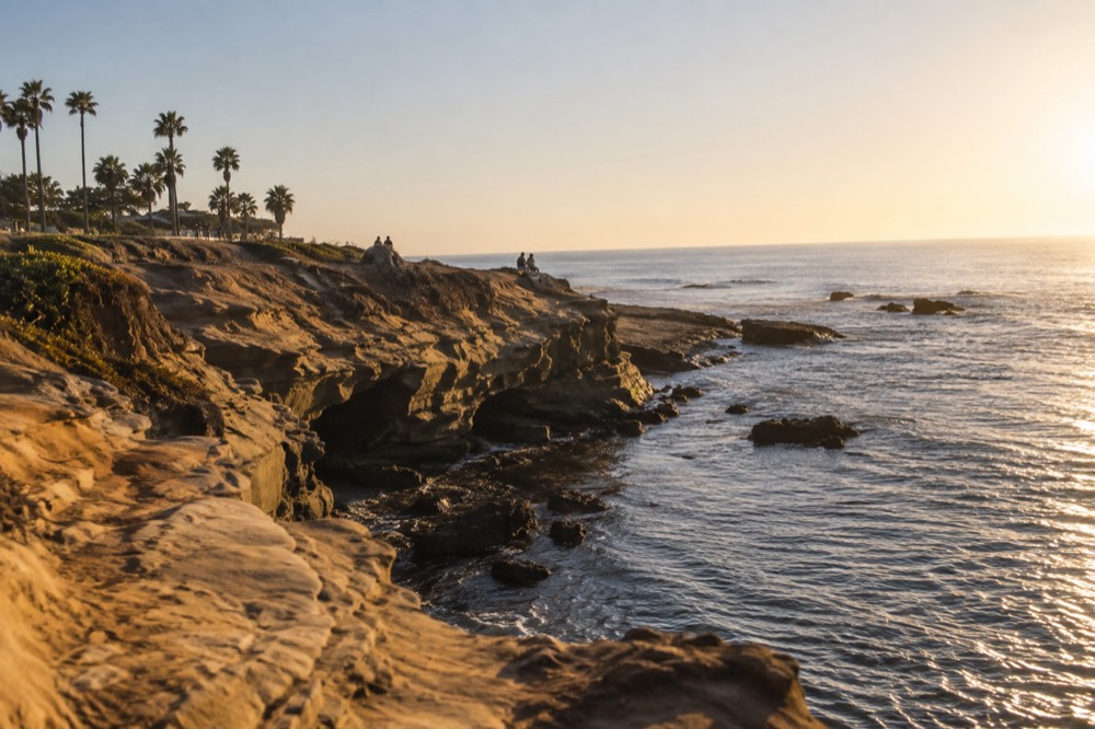 Golden evening light on the sandstone cliffs and calm water at La Jolla Cove