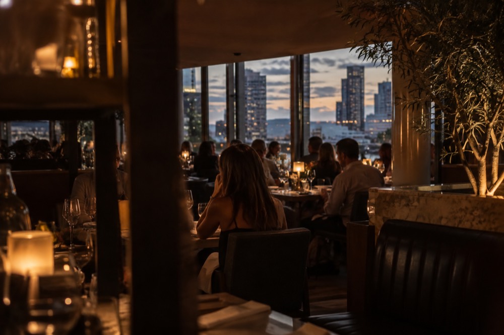 Evening view of a busy San Diego restaurant dining room with warm lighting