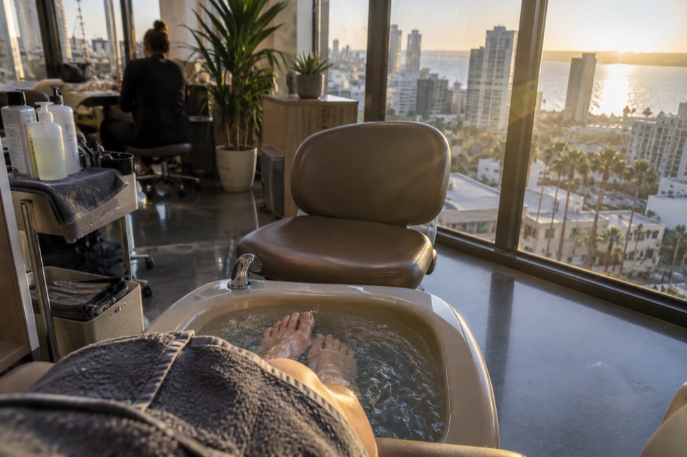 A close-up of a pedicure station with a foot bath and technician chair