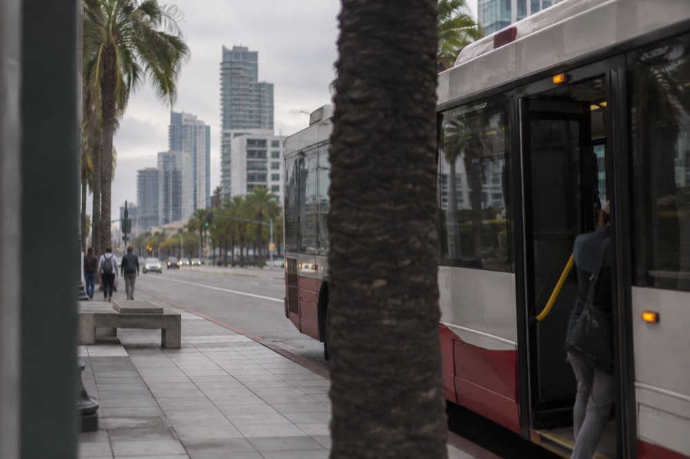 A city bus stopped on a downtown San Diego street near the waterfront
