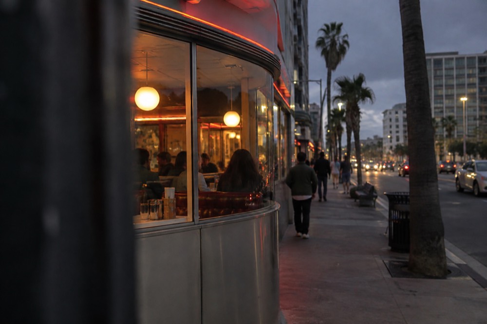 A neon-lit diner storefront on a San Diego street at dusk