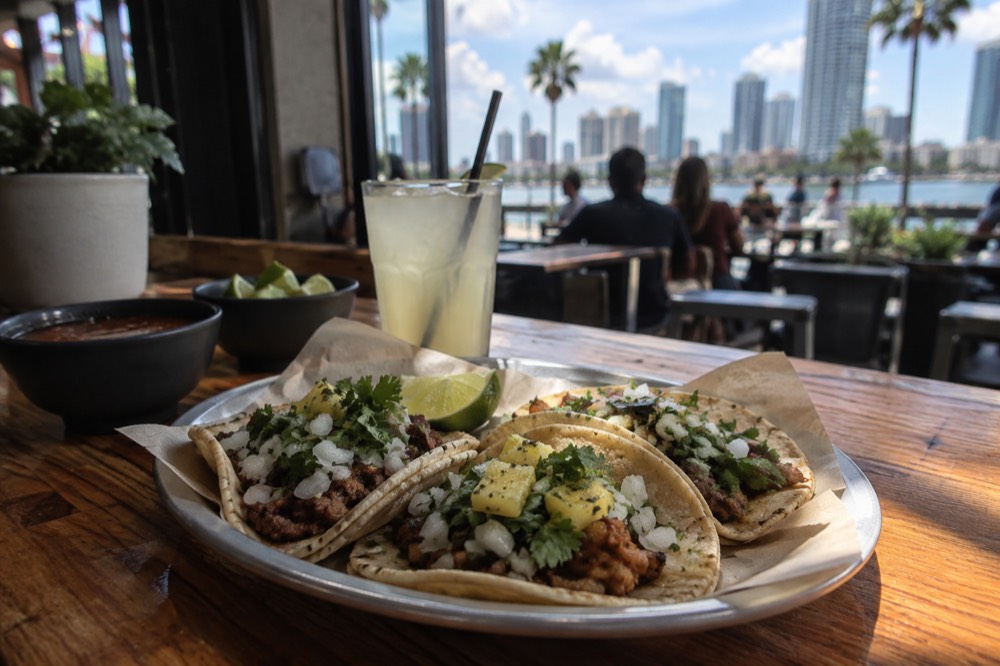 Freshly prepared tacos on a wooden counter in a casual San Diego restaurant