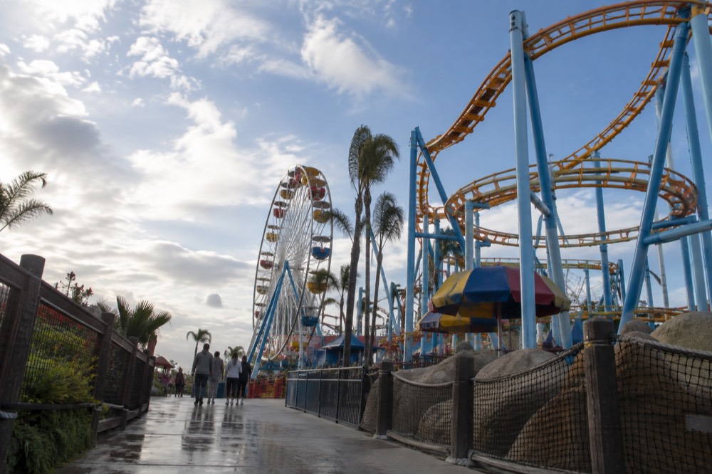 Colorful theme park rides and bright attractions seen from a pathway