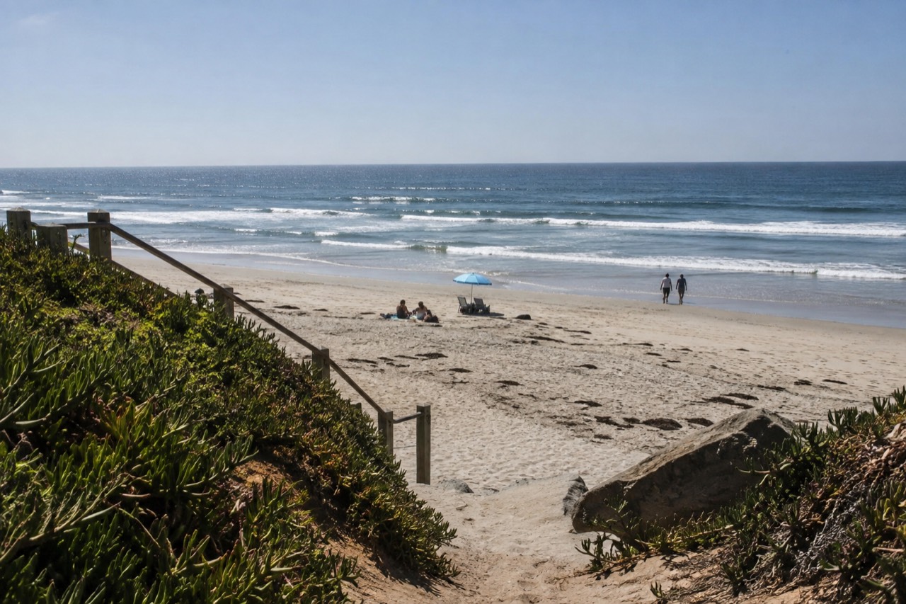 Carlsbad beach with gentle waves and a wide sandy shore under a clear sky
