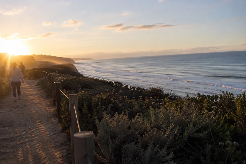 Coastal walking path on a bluff top with ocean horizon in the distance near Del Mar