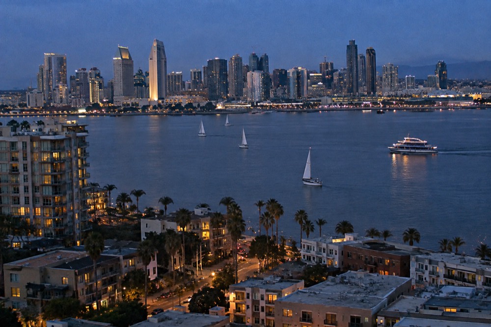Sailboats and a sightseeing boat on San Diego Bay with the city skyline behind