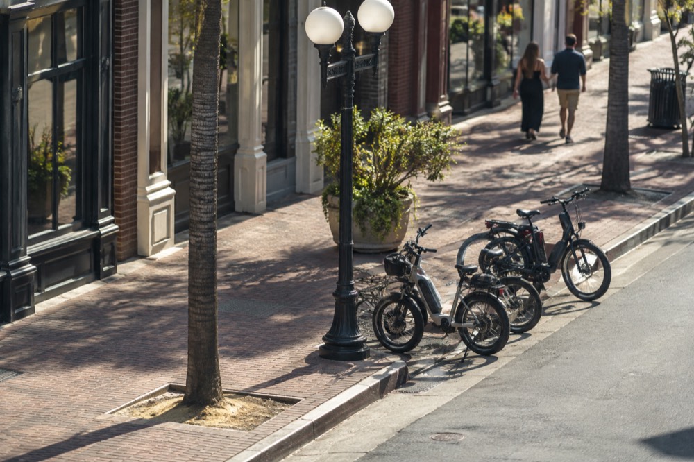 Electric bikes parked on a downtown street beside historic storefronts