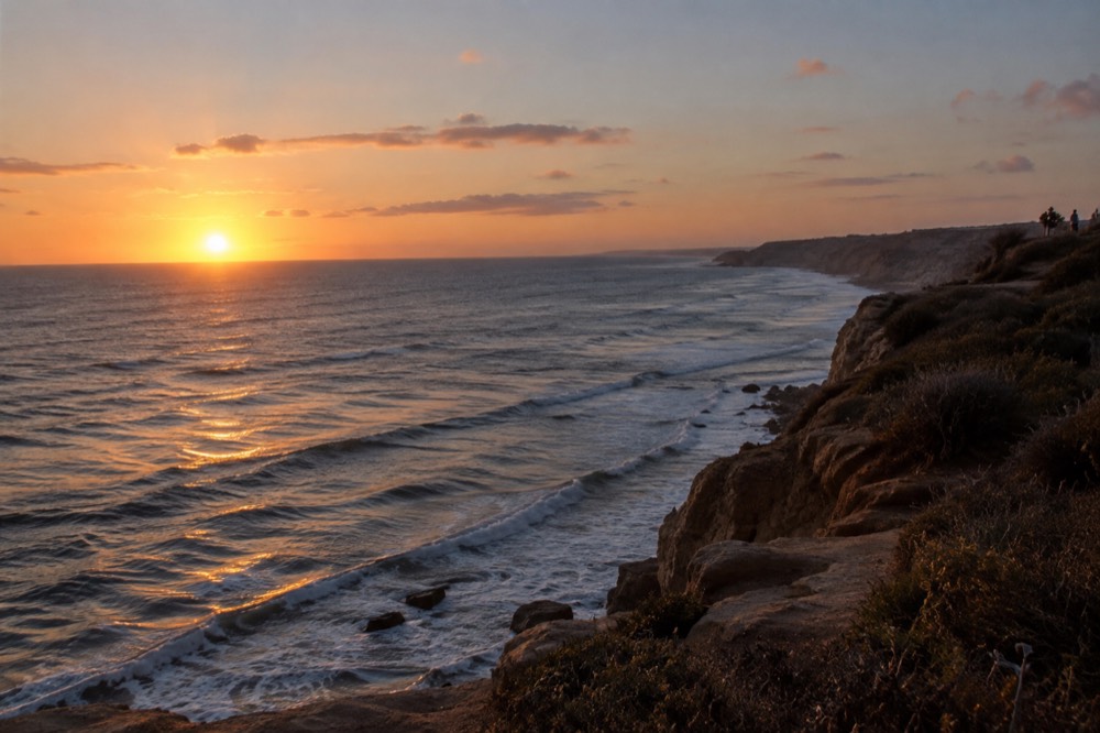Sunset over the Pacific from the Point Loma cliffs with waves below