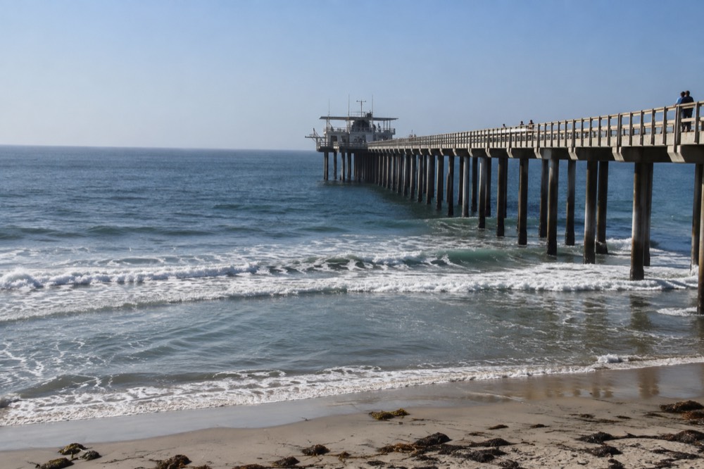 A research pier extending over the Pacific Ocean beside a sandy beach