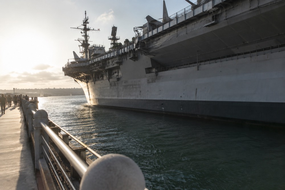 A historic aircraft carrier ship museum moored along a downtown waterfront
