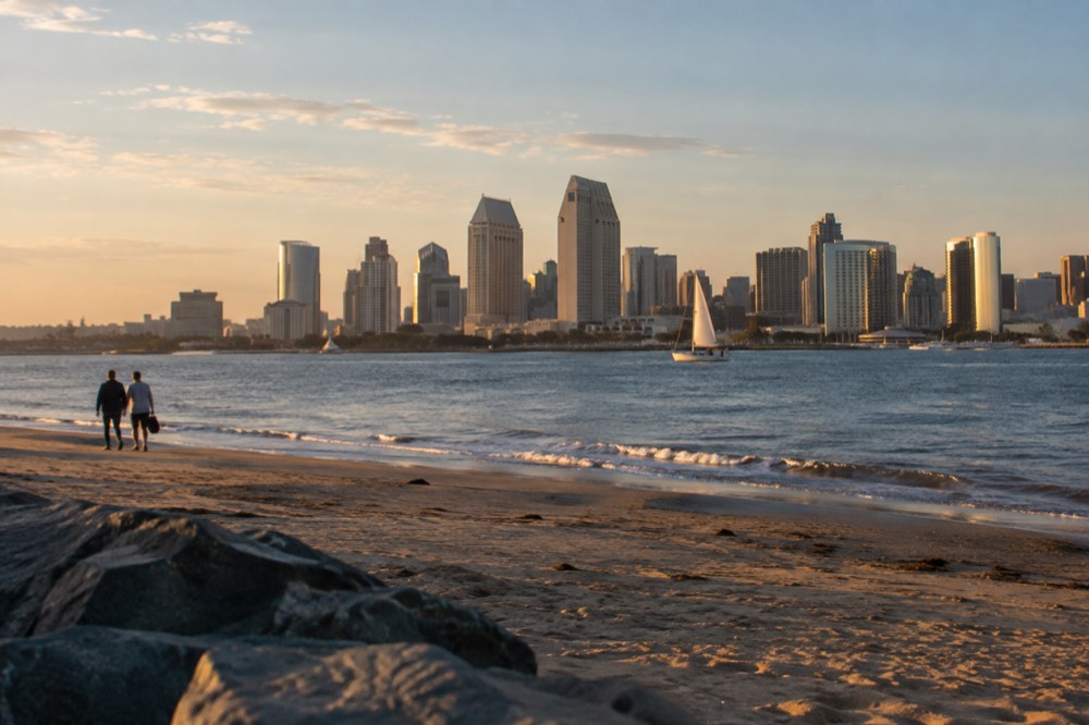 View across San Diego Bay from Coronado Beach toward downtown towers at golden hour