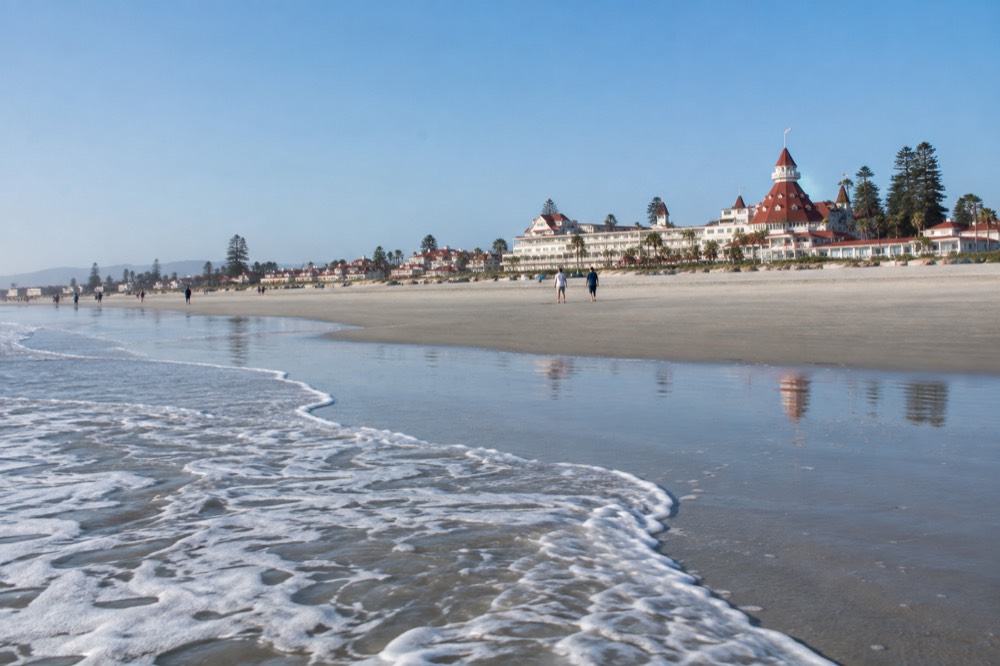 Gentle waves rolling onto a wide empty beach in warm morning light
