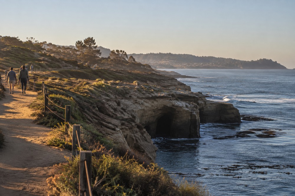 Bluff top walking trail above the ocean with views down to sea caves and kelp beds
