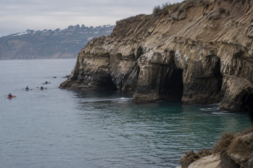 Calm turquoise water at the base of sea cliffs in early morning light