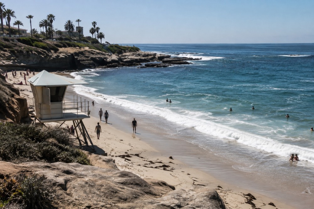 Lifeguard tower overlooking a curved sandy beach with rocky point beyond
