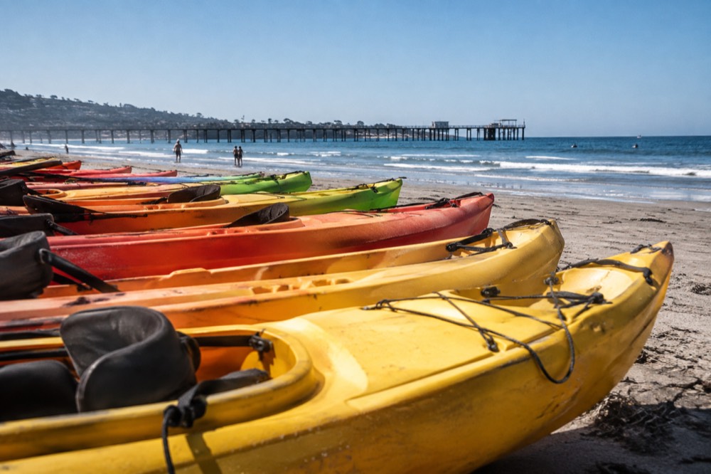 Kayaks lined up on the sand at the north end of La Jolla Shores near the pier