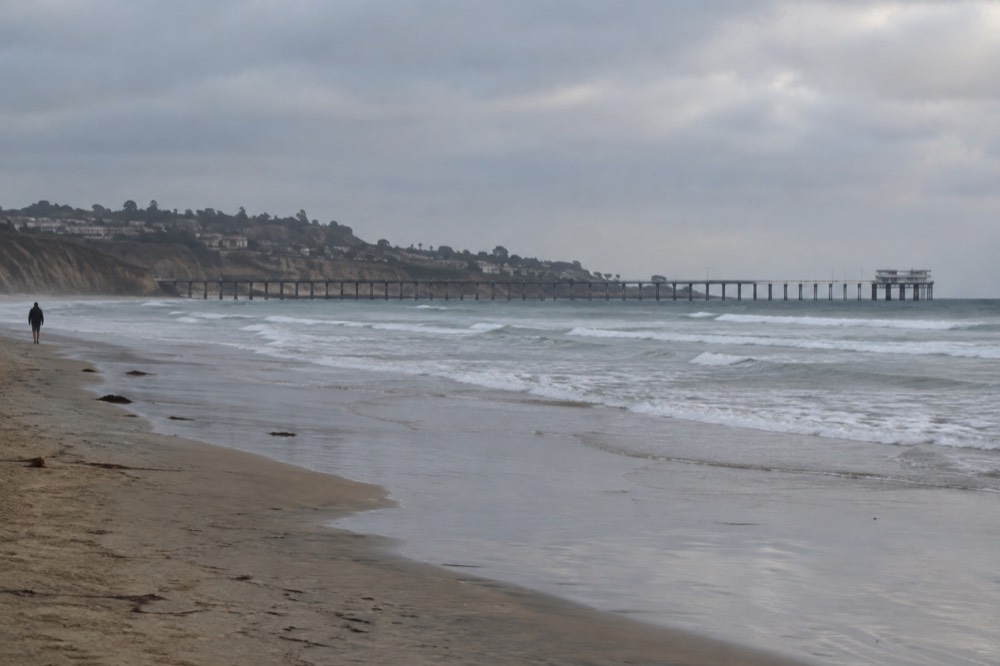 Empty beach at La Jolla Shores in late afternoon light with the pier in the distance
