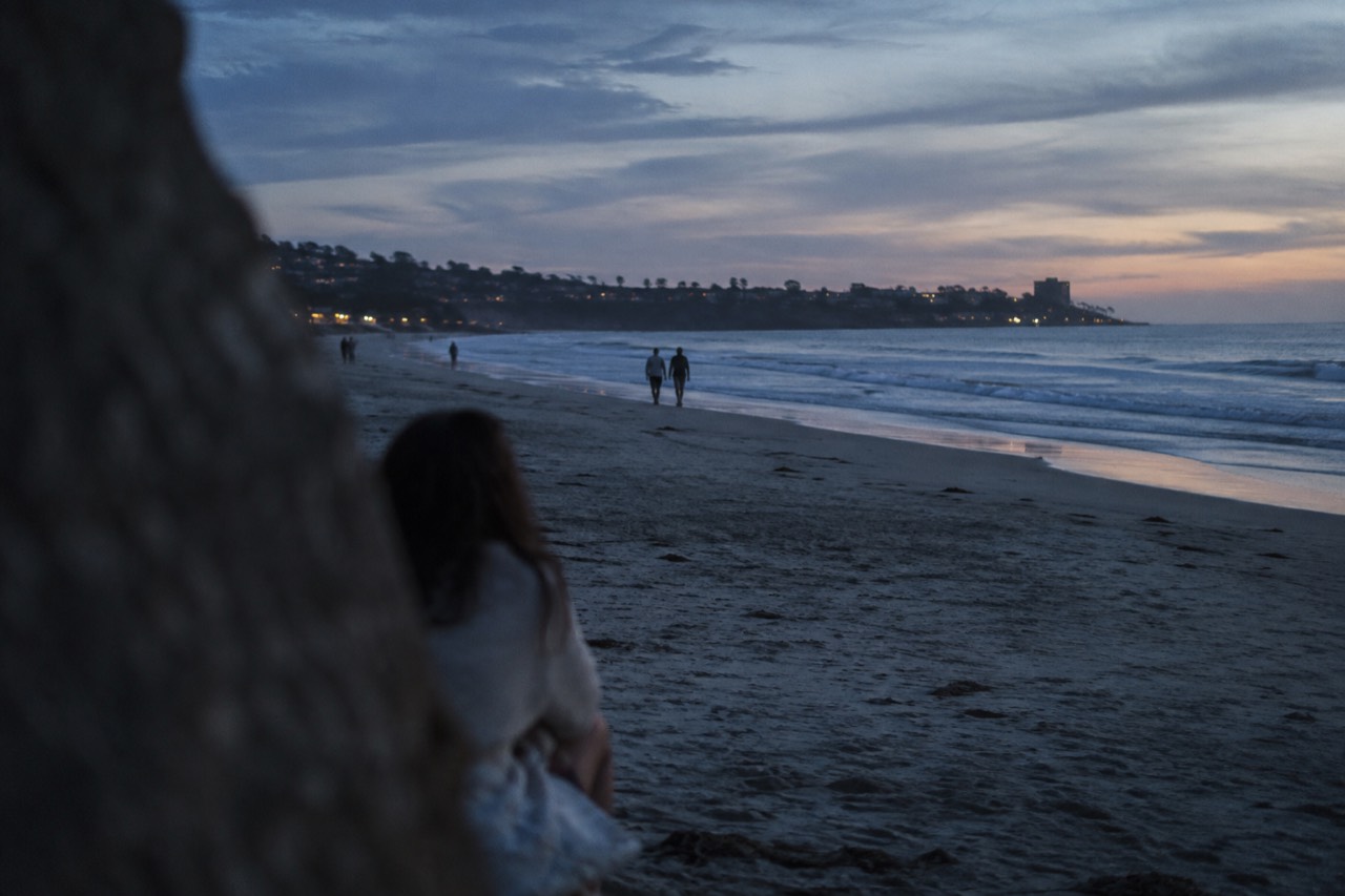 Wide sandy beach at La Jolla Shores with gentle waves and the La Jolla coastline in the distance