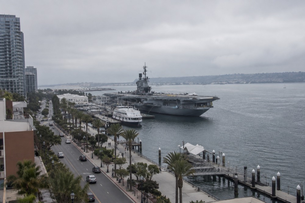 View along the Embarcadero waterfront toward a moored aircraft carrier