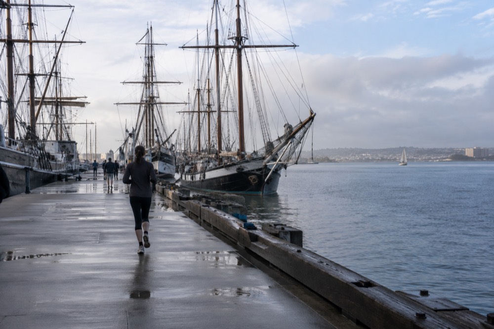 Masts of tall ships against a soft morning sky over San Diego Bay