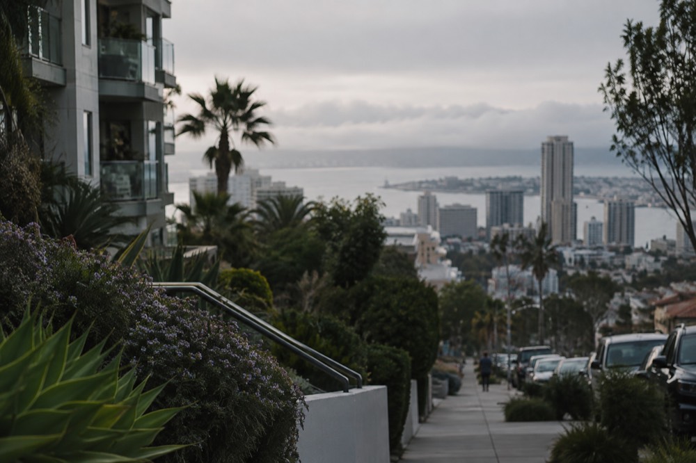Low marine layer clouds resting over the ocean with clear sky above a hilltop