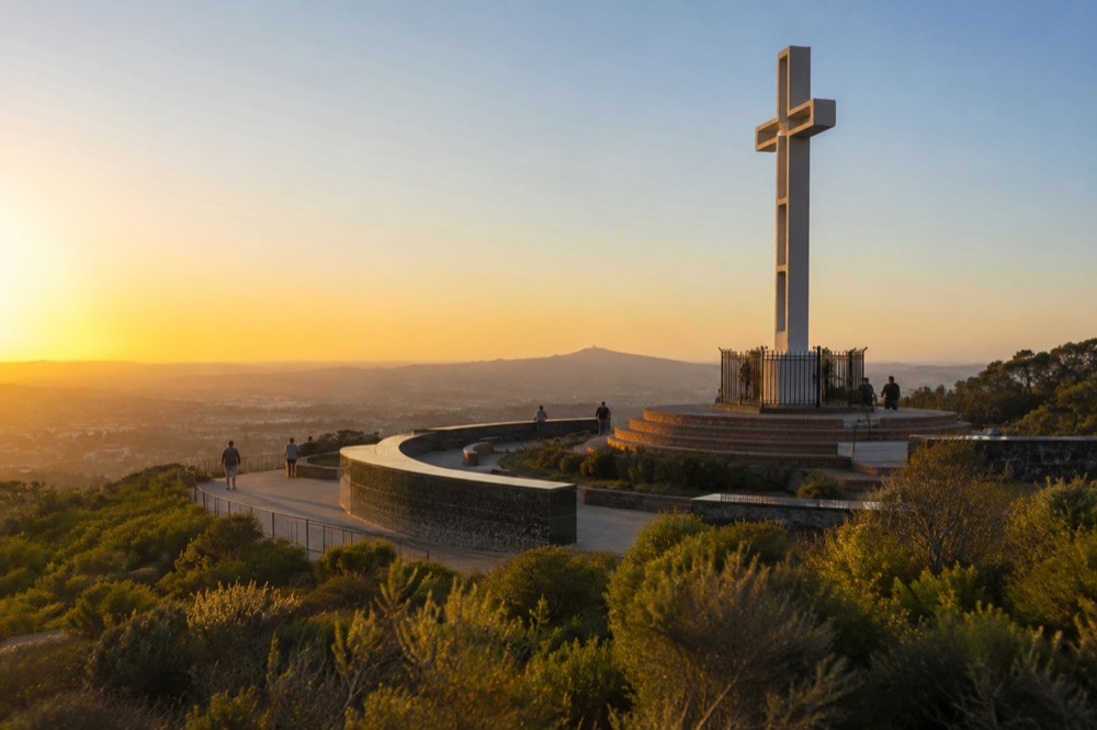 Open hilltop plaza with memorial plaques and a wide sky above the coast