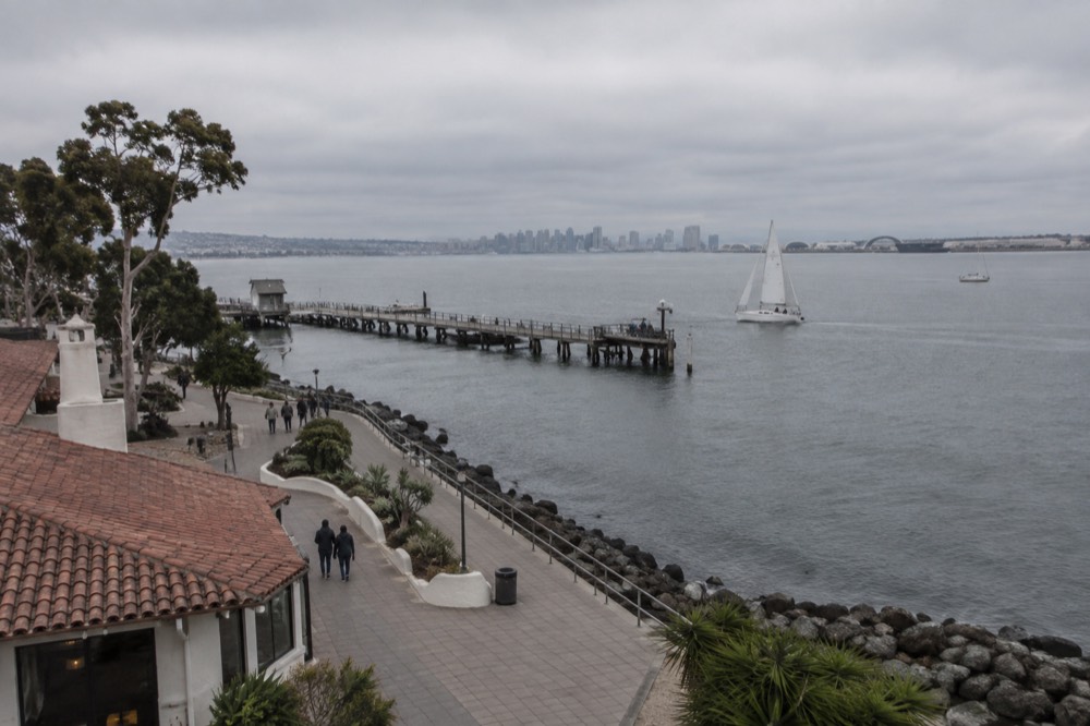 Boardwalk along the bay with sailboats on the water