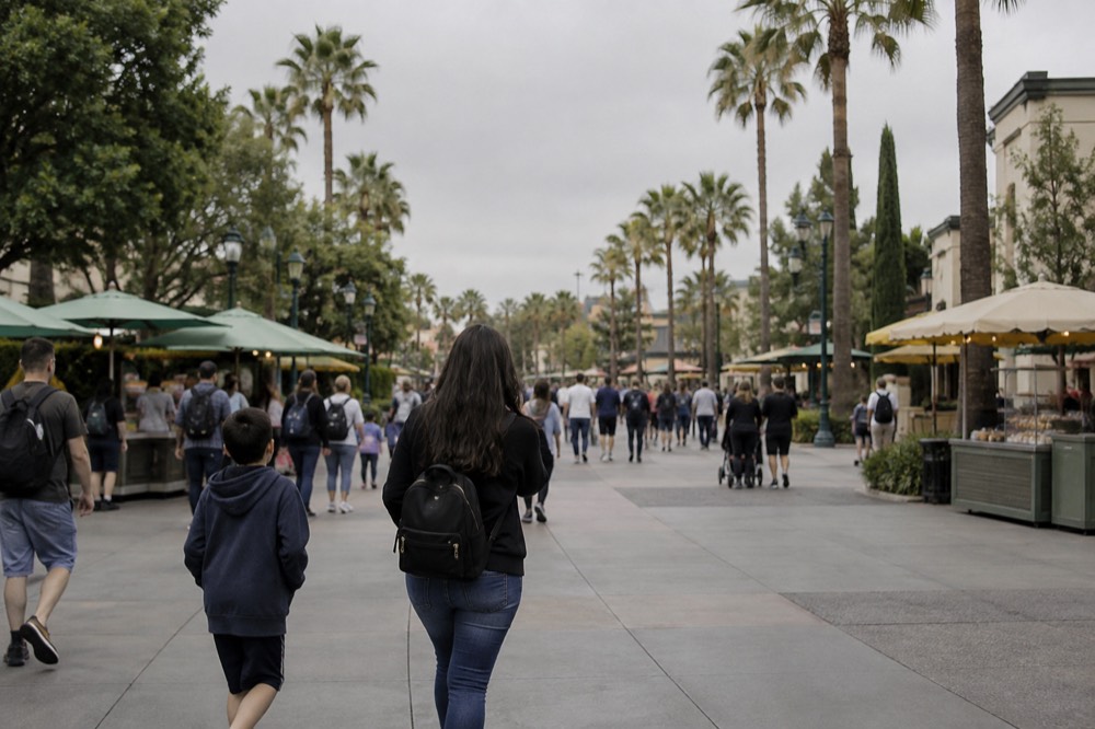 Families walking a theme park main street with snack stands