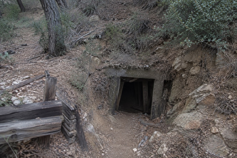 An old mine entrance in wooden hillsides