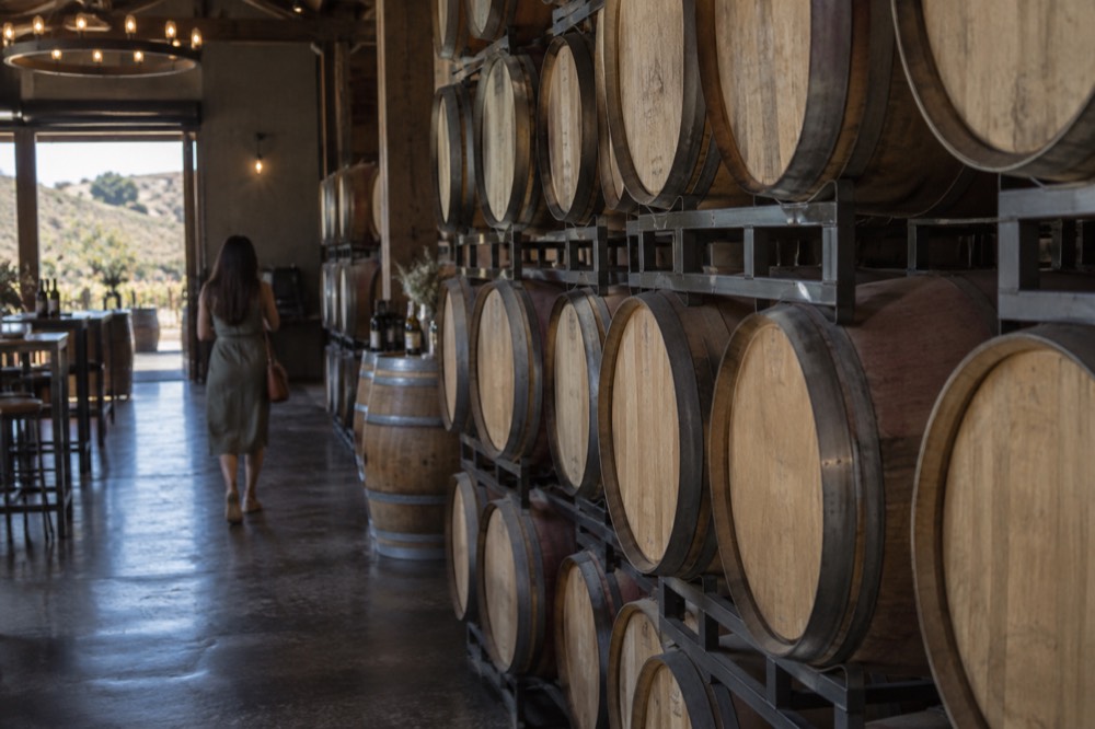 Barrels stacked inside a dim winery tasting room
