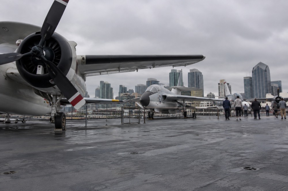 A wide museum hangar deck with historic aircraft and a level walkway