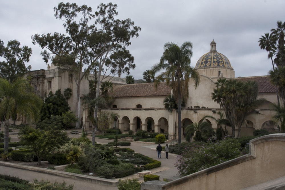 A museum facade with arched colonnades and tiled dome in Balboa Park