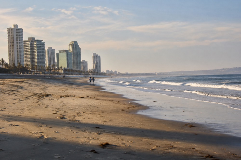 Empty beach at early morning with long shadows across the sand and gentle surf