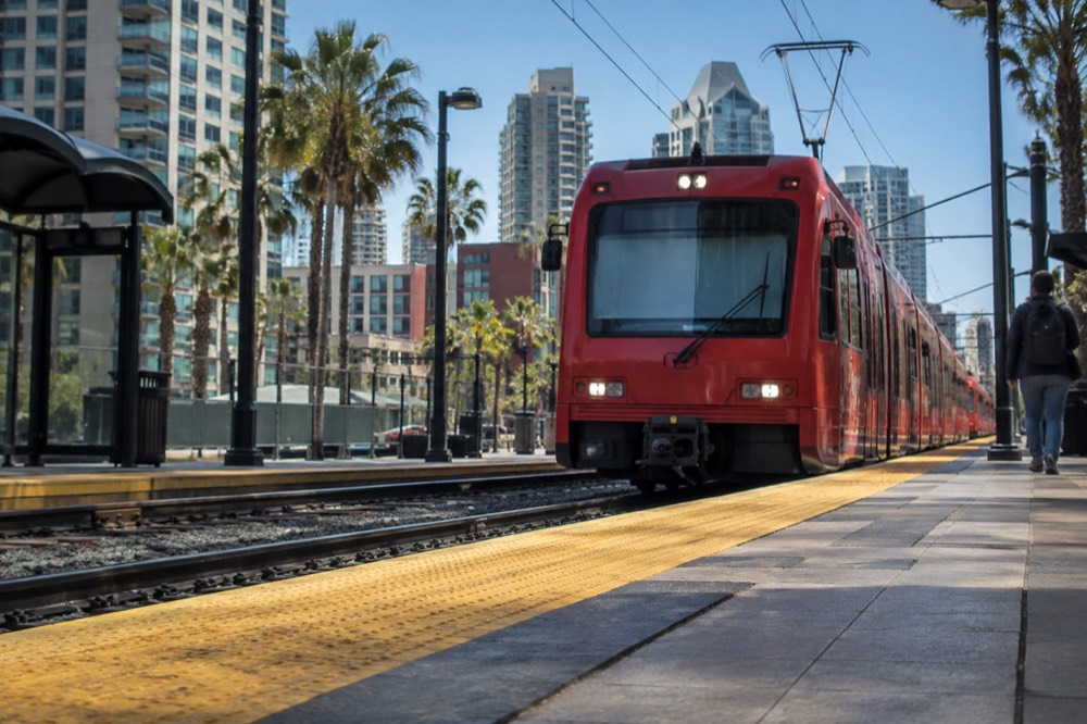 Red trolley arriving at a downtown San Diego station platform