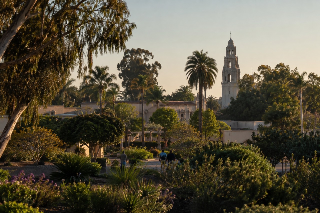 Wide view of Balboa Park gardens with the California Tower in the distance on a clear afternoon
