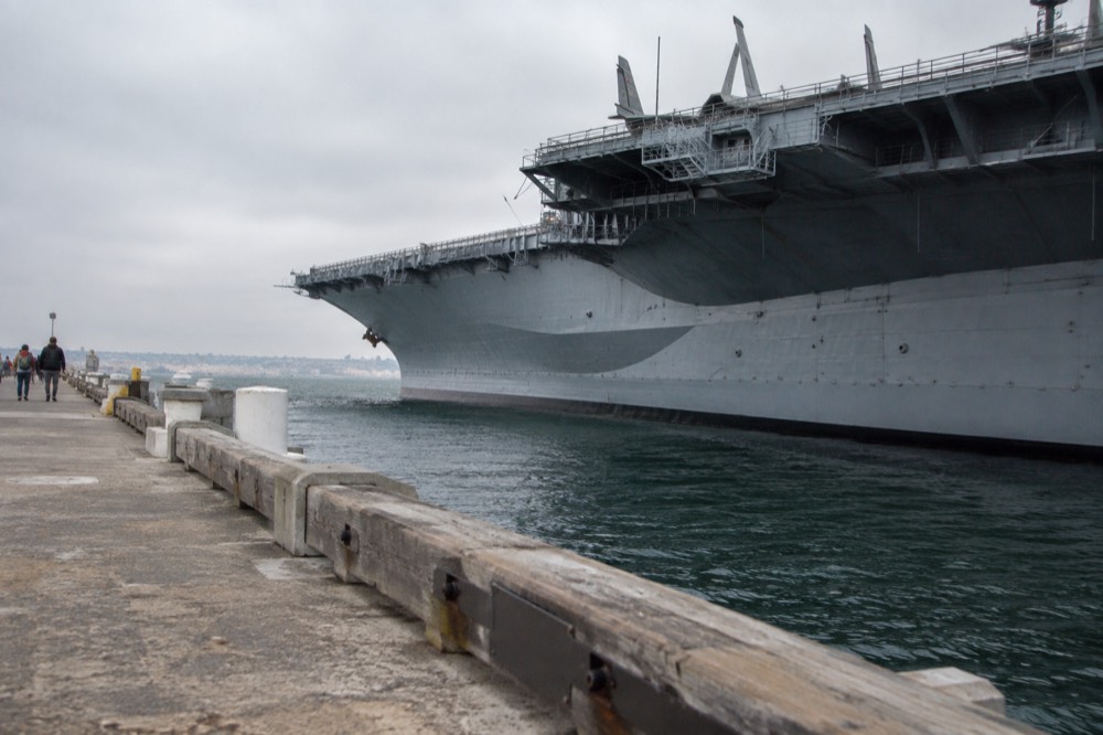 Embarcadero waterfront promenade with the USS Midway ship moored along the bay