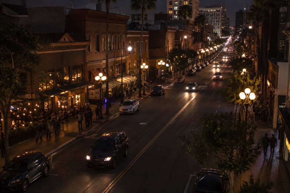 Gaslamp Quarter street at night with lit restaurant signs and sidewalk tables