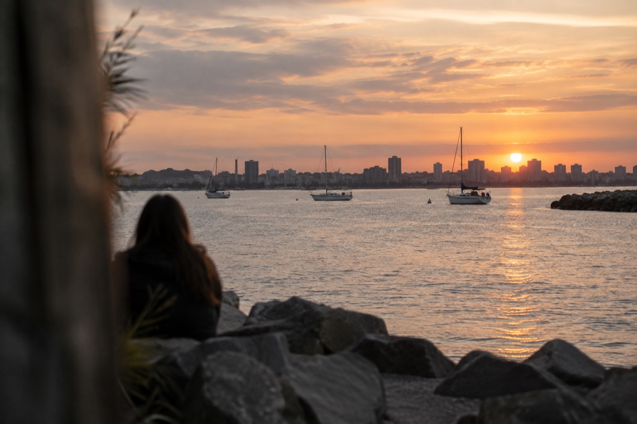A quiet San Diego bay shoreline at sunset with sailboats on calm water