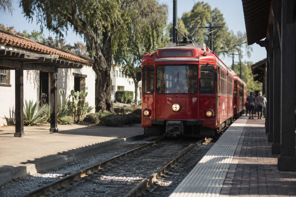 Red trolley car arriving at an Old Town San Diego transit station platform