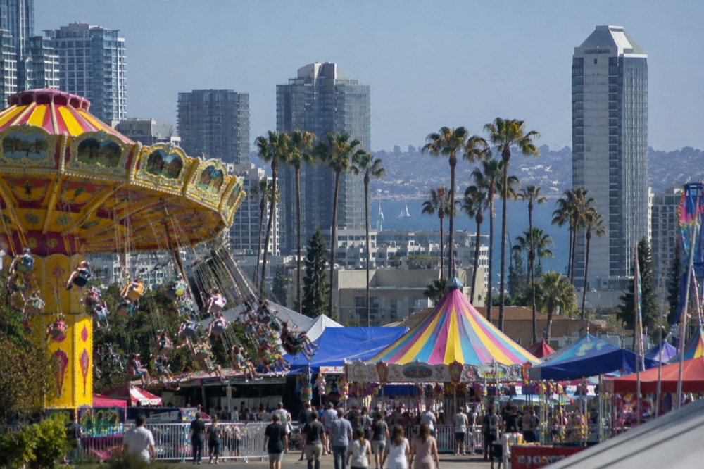 Children's carnival area with small rides and colorful bunting under a blue sky