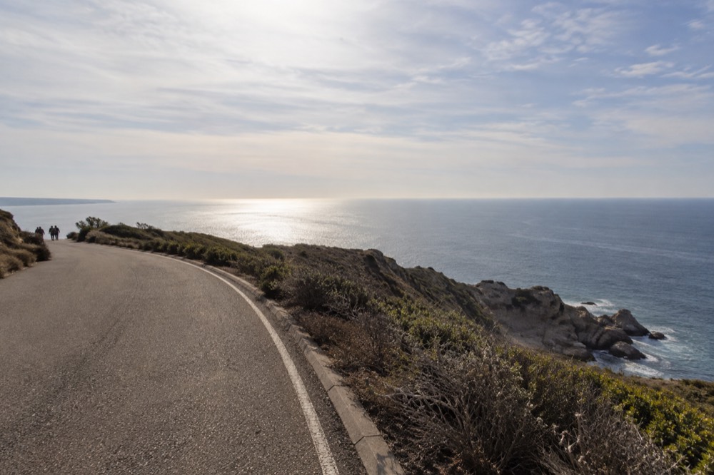 Coastal road above a rocky point with ocean horizon in morning light