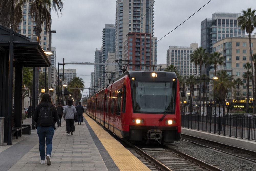 A red San Diego trolley pulling into a downtown station platform