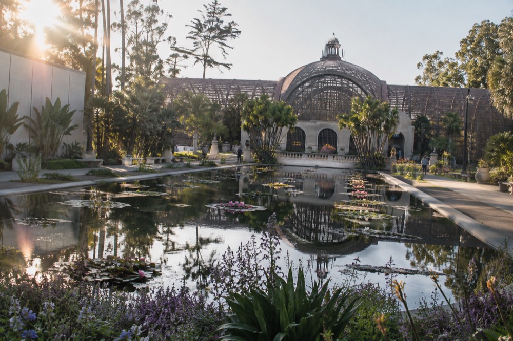 The Botanical Building and lily pond in Balboa Park with reflected flowers on the water