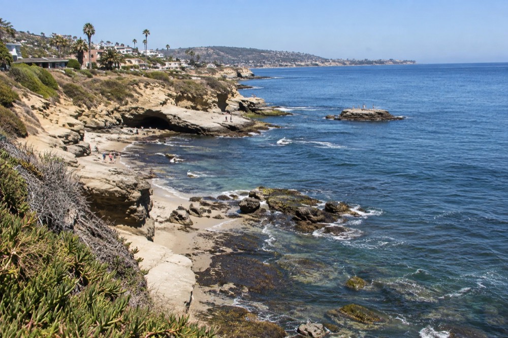 Clear morning over La Jolla coastline with calm blue ocean and rocky bluffs